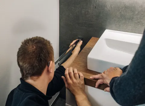 Anlagenmechaniker SHK montieren Handtuchhalter.