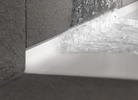 Detail der BetteFloor Zarge in Weiß mit grauen Naturstein-Fließen