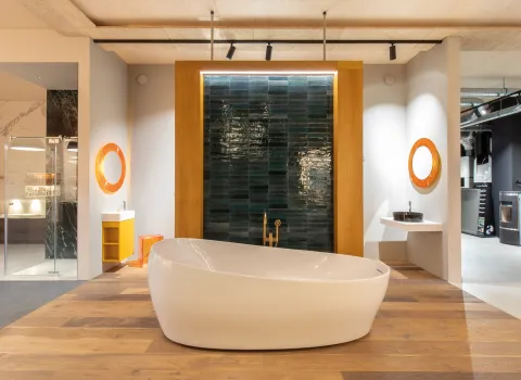 Badewanne vor Wand mit blauen Fliesen in der Badausstellung der Prehn & von Hoeßlin GmbH & Co. KG in Ahrensburg.