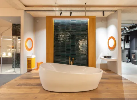 Badewanne vor Wand mit blauen Fliesen in der Badausstellung der Prehn & von Hoeßlin GmbH & Co. KG in Ahrensburg.