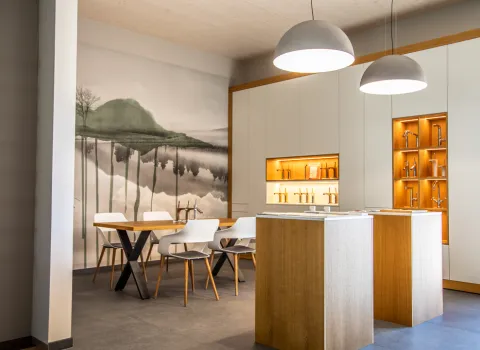 Tisch zur Beratung vor bemalter Wand und Armatur-Mustern in der Badausstellung der Prehn & von Hoeßlin GmbH & Co. KG in Ahrensburg.