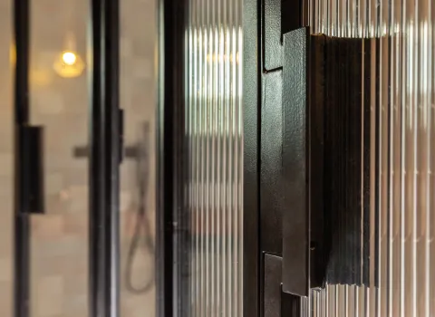 Schwarzer Griff der Walk-In-Dusche im Penthouse-Referenzbad vom Handwerksunternehmen Prehn & von Hoeßlin GmbH & Co. KG.