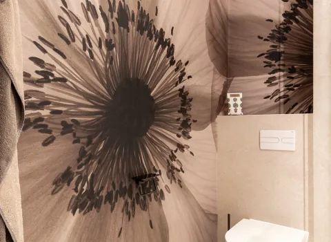 Florales Wanddesign neben dem WC im Referenzbad der Prehn & von Hoeßlin GmbH & Co. KG.