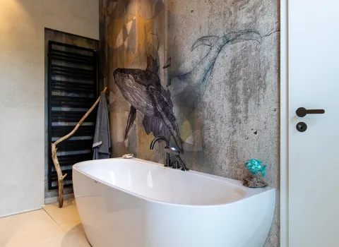 Freistehende Badewanne von künstlerischer Wand mit Walbild im Referenz-Badezimmer von Prehn & von Hoeßlin GmbH & Co. KG.
