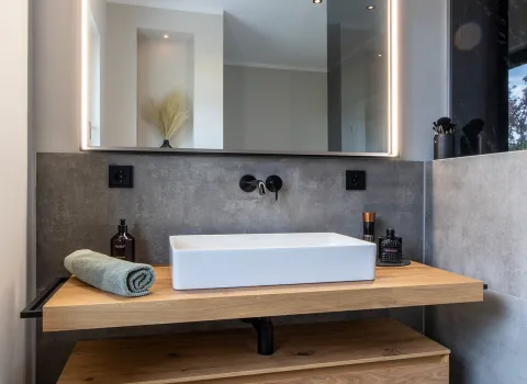 Schöner, heller Waschtisch aus Holz im Stonehenge-Referenzbad vom Handwerksunternehmen Prehn & von Hoeßlin GmbH & Co. KG.