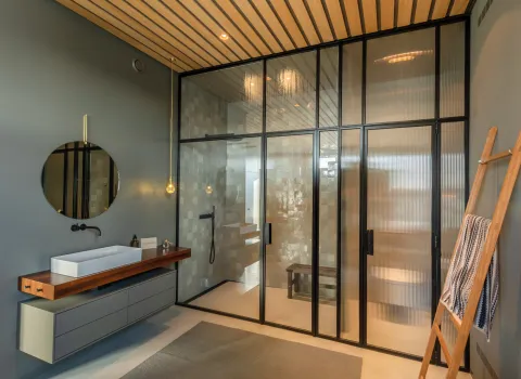 Walk-In-Dusche und edler Waschtisch aus Holz im Penthouse-Referenzbad vom Handwerksunternehmen Prehn & von Hoeßlin GmbH & Co. KG.