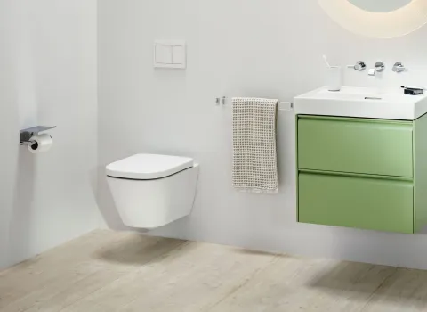Ein modernes Badezimmer mit einem wandhängenden WC in minimalistischer Ausführung und hellen Farben.