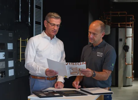 Michael Prehn von Prehn & von Hoeßlin im Gespräch mit einem Kunden, beide betrachten gemeinsam ein Produktmagazin.