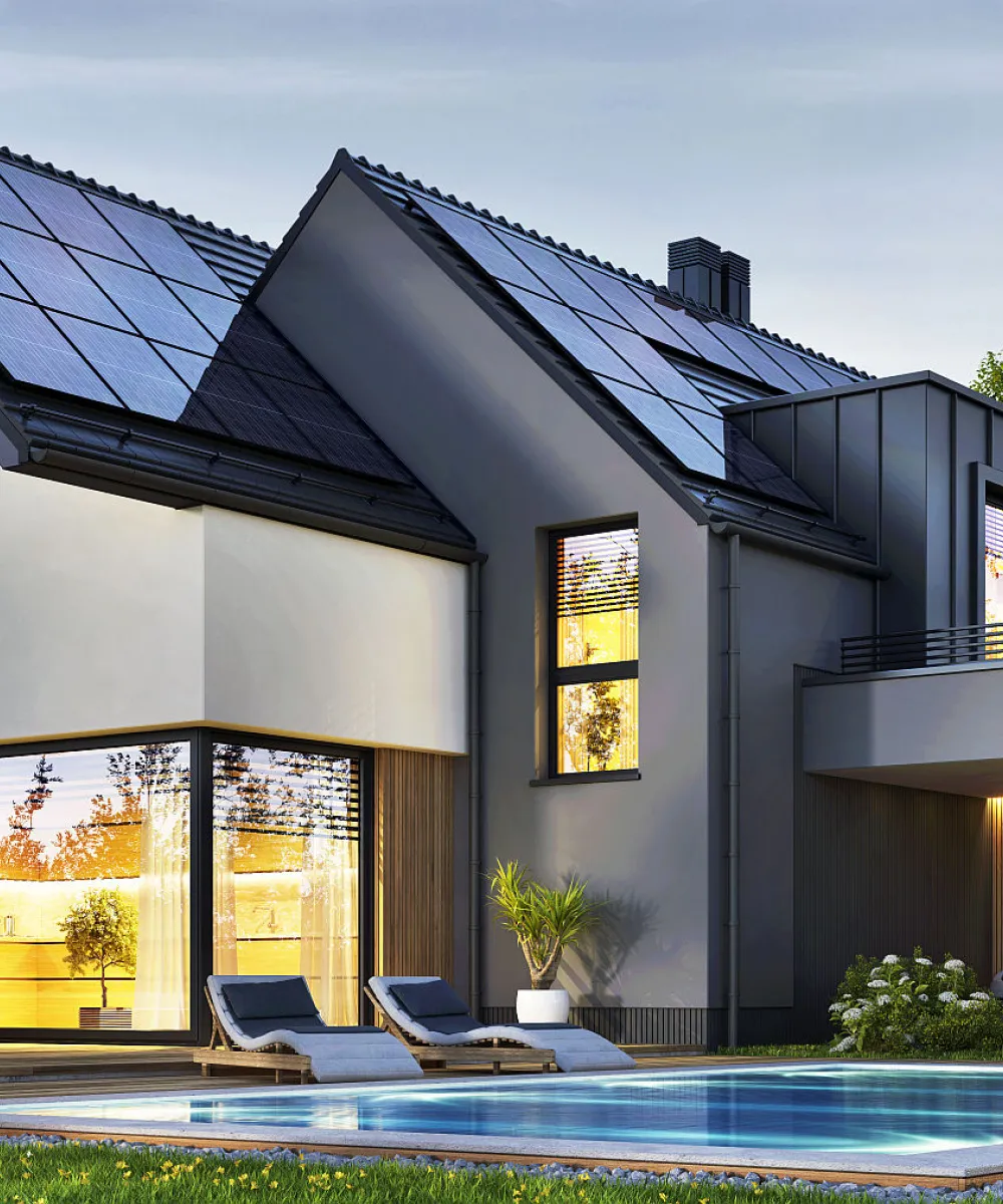 Das Bild zeigt ein energieeffizientes Einfamilienhaus mit Solaranlage, Elektroauto-Ladestation und einem Pool im gepflegten Garten.