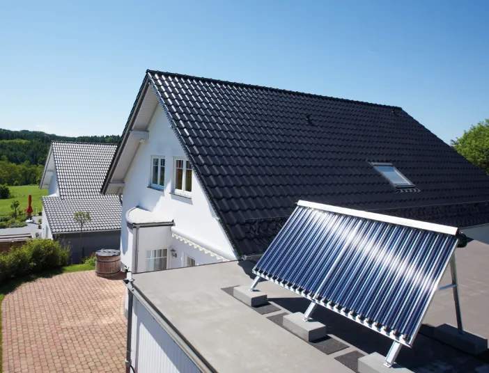 Ein Haus mit Solarkollektor auf dem Flachdach der Garage.