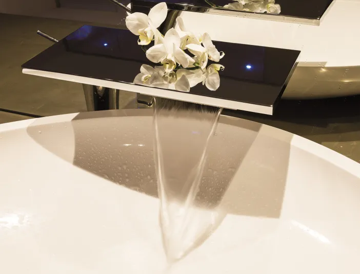 Edle Waschbecken-Armatur mit Blumen-Dekoration im Referenzbad vom Handwerksunternehmen Prehn & von Hoeßlin GmbH & Co. KG.