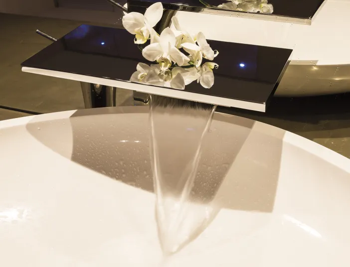 Edle Waschbecken-Armatur mit Blumen-Dekoration im Referenzbad vom Handwerksunternehmen Prehn & von Hoeßlin GmbH & Co. KG.