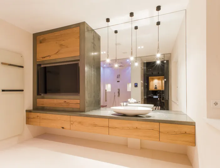 Waschtisch-Element aus Holz mit Fernseher und großem Spiegel vom Handwerksunternehmen Prehn & von Hoeßlin GmbH & Co. KG.