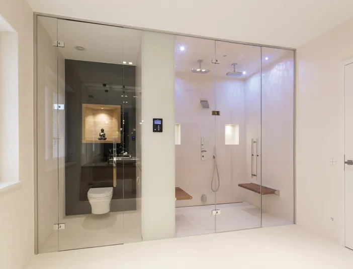 Edle Walk-In-Dusche und WC mit beleuchteter Statue im Referenzbad vom Handwerksunternehmen Prehn & von Hoeßlin GmbH & Co. KG.