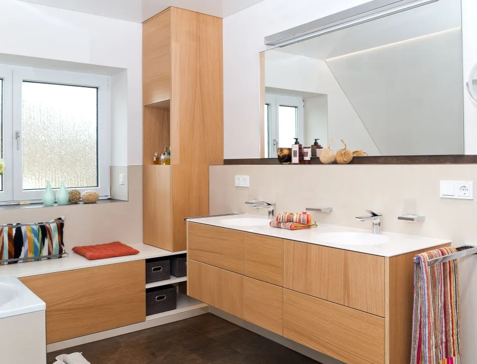 Helles Badezimmer mit wohnlichen Holzmöbeln und Doppelwaschbecken.